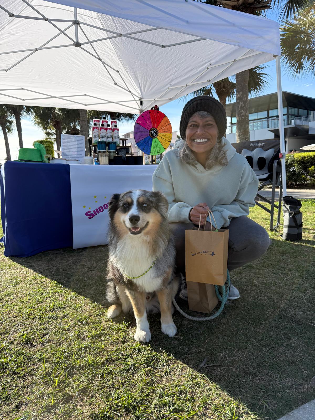 Customer and dog visiting the Shooting Star Products booth at the Jax Beach Market in Jacksonville Beach, Florida