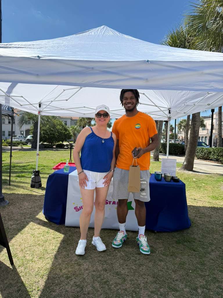 Michelle Sawyer with a customer at the Shooting Star Products booth during the Jax Beach Market in Jacksonville Beach, Florida